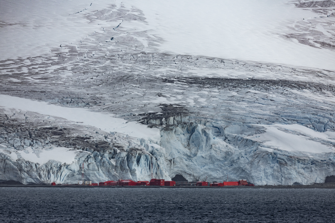 red shipping containers can be seen gathered in front of a vast icy landscape in antarctica red shipping containers can be seen gathered in front of a vast icy landscape in antarctica